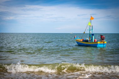 Mavi balıkçı teknesi mavi gökyüzüyle iskelede beyazlatılmış..