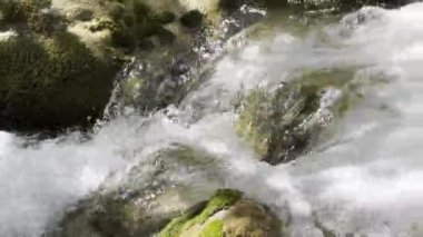 Doğanın dingin güzelliğini engebeli dağlardan yavaşça akan bu büyüleyici su videosuyla, yemyeşil yosunlarla bezenmiş yıpranmış bir kayanın etrafında şelale gibi akan.