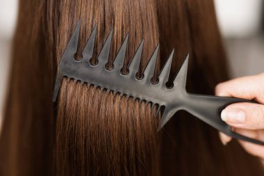 Saç bakım konsepti. Güzel Saçlarını Tarayan Çekici Genç Bayan. İsimsiz bir kadın banyoda otururken arkadaşının saçını fırçayla tarıyor..