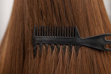 Genç Bayan Modelin Uzun Islak Saçlı Maskeyi Tarak ile Tazeleyen Yakın Çekimi. Tarakla saç fırçalayan güzel bir kadın. Sağlık Hizmetleri. Yüksek Çözünürlük