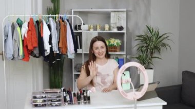 Kafkas kadın moda tasarımcısı cep telefonu siparişi alıyor ve mağazada canlı yayın yapan kıyafetleri gösteriyor. Küçük işletme sahibi, çevrimiçi pazar dağıtımı kavramı.