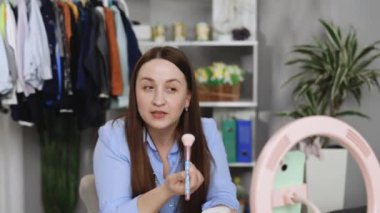 Güzel kadın ve profesyonel güzellik makyaj sanatçısı vlogger makyaj dersini internet sitesinden ya da sosyal medyadan paylaşmak için beuty stüdyosunda kaydediyor. Blogcu tripod ve halka lambasında dijital kamera kullan