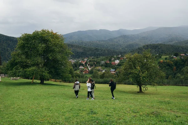 Grupp Unga Turister Går Genom Hage Liten Bergsstad Mot Bakgrund — Stockfoto