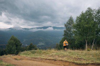 Dağlardaki komik genç bir adam yürüyüş sırasında yüzünde bir gülümsemeyle ormandan çıkar..
