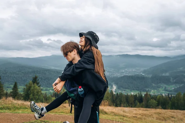 아름다운 남녀가 아름다운 경치를 배경으로 산에서 남자는 여자를 어깨에 — 스톡 사진