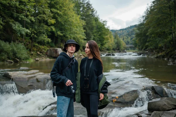 Foto Dois Jovens Turistas Elegantes Uma Margem Rochosa Rio Montanha — Fotografia de Stock