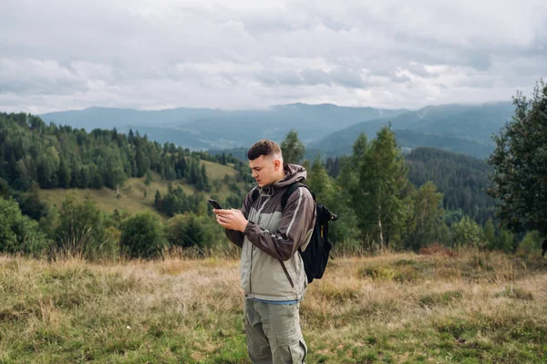 산속을 하이킹하는 관광객들은 아름다운 풍경을 배경으로 얼굴에 초점을 스마트폰을 — 스톡 사진