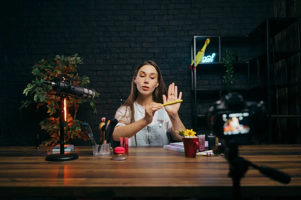 녹음실에서 비디오를 녹화하고 비디오를 만드는 카메라에 화장품 튜브를 매력적 미녀의 로열티 프리 스톡 이미지