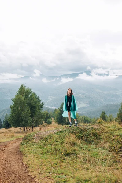 산에서 비옷을 관광객의 그려진 카메라를 대조적 하이킹 스톡 사진