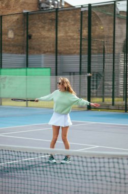 Spor yapan bayan bir tenis oyuncusunun tenis kortunda topa vuruşunun fotoğrafı. Tenis bir hobidir..