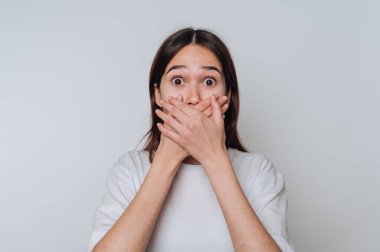 Şaşırmış Asyalı kız gündüz saatlerinde elleri ile ağzını kapatıyor.