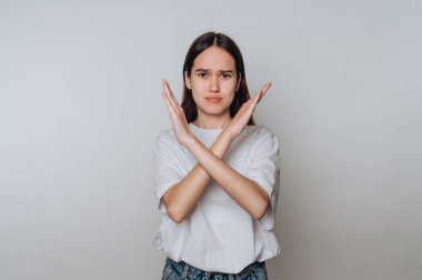 Genç Asyalı bir kadın arka planda çapraz kollarla reddediyor.