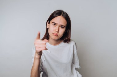 Genç bir kadın, hafif bir stüdyo ortamını işaret ederken onaylamadığını ifade ediyor.