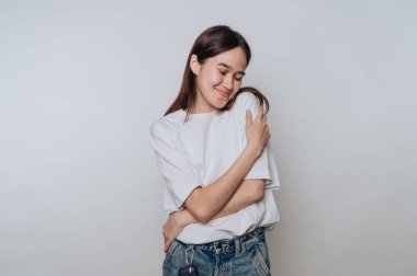 Kapalı bir ortamda kendini sıcak bir gülümsemeyle kucaklayan bir kadın