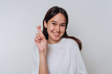 Genç Asyalı kadın gün boyunca şans dilemek için gülümsüyor ve dua ediyor.