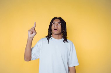 Genç bireysel hareketler parlak sarı bir arkaplana karşı yukarı doğru hareket ederken merak veya ilham ifade eder