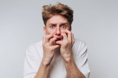 Genç adam, kişisel bir sıkıntı anında tarafsız bir ortamda korku ve endişe ifade eder.