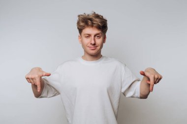 Genç insan kapalı mekanda minimalist bir ortamda el kol hareketi yaparken, rahat ve oyuncu bir tavır sergiliyor.