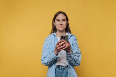 İçerik olarak genç bir kadın telefon görüşmesinden zevk alıyor. Neşesini ve canlı sarı arka plandaki bağlantısını yakalıyor.