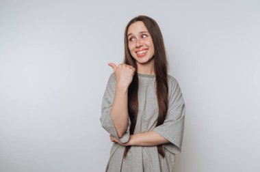 Genç bir kadın neşe içinde gülümser ve el kol hareketi yapar, neşe ve pozitiflik saçarak beyaz arka planda mutluluk ve arkadaşlığın özünü yakalar.