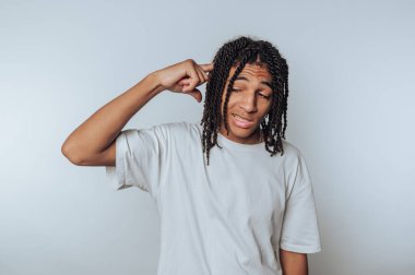 Kafasında örgülü saç jestleri olan, derin düşünceleri simgeleyen ya da beyaz arka plan üzerine kafa yoran biri.