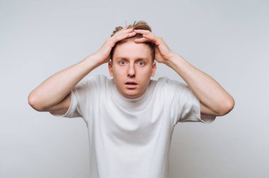 Adam kafasını boş bir alanda tutarken şok ve şaşkınlık gösterir.