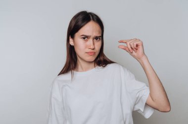 Genç bir kadın, evde günlük kıyafetlerle küçük bir jest yaparak hayal kırıklığını ifade ediyor.