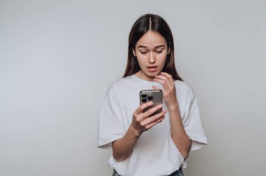 Genç bir kadın akıllı telefonundan gelen sürpriz mesaja evde günlük kıyafetlerle cevap veriyor.