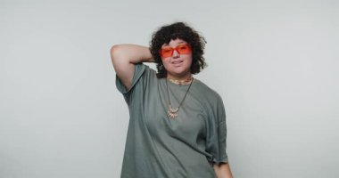 Neon güneş gözlüklü genç kadının hayal kırıklığı, beyaz arka plandaki duygusal karmaşıklığı ve iç çatışmayı vurguluyor