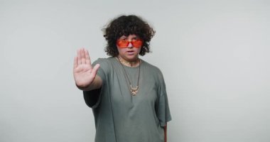 Kırmızı gözlüklü genç kıvırcık kadın elini uzatıyor ve beyaz arka planda özgüven ve sınır konularını tanıtıyor.