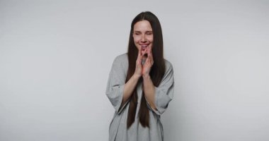 Heyecanlı kadın, minimalist bir yerde yaratıcı bir stüdyo oturumunda kutlama için el çırpıyor.