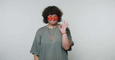 Kapalı bir ortamda parlak güneş gözlüğü takan kişi, kendine güvenini ve tarzını belli eder.