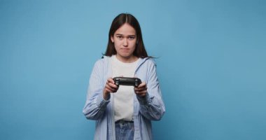 Genç oyuncu, açık mavi bir ortamda rekabetçi bir oturum sırasında duygular yükselirken oyuna odaklandı