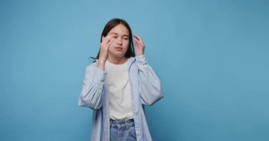 Mavi arka plandaki kız, yaratıcı bir oturum sırasında ince jestler ve hareketlerle duygularını yorar.