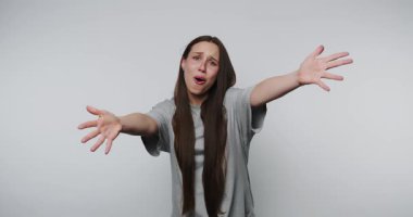 Genç bir kadın duygularını ifade ediyor ve seyirciyle minimalist bir ortamda yaratıcı bir performans sergiliyor, ellerini kameraya gösteriyor ve sarılmak istiyor.