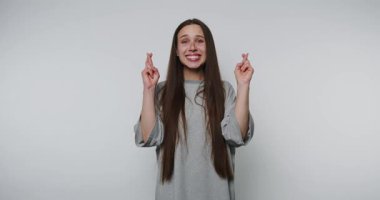 Heyecanlı genç bir kadın parmak çapraz hareketleriyle içeride coşku gösteriyor.