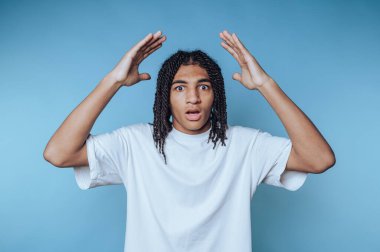 Şaşkın bakışlı, elleri havada, mavi bir geçmişi olan genç adam..