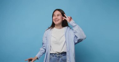 Neşeli bir şekilde poz veren ve gülümseyen genç bir kadın.