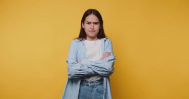 Parlak sarı bir arkaplan karşısında rahat olmadığını ifade eden bir kadın.