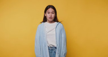 Genç bir kadın, ev ortamında canlı sarı bir arka plana şaşırdığını ifade ediyor.