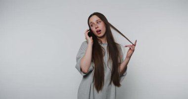 Büyük tişörtlü kadın telefonda arka planda sessizce konuşuyor.