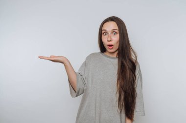 Uzun saçlı genç bir kadının portresi, açık arkaplanda huşu içinde elini uzatıyor.