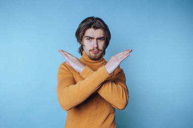 Genç adamın portresi mavi arka planda çapraz kollu kendinden emin bir tavır sergiliyor.