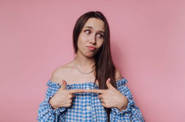 Genç bir kadının portresi, pembe arka planda düşünceli bir şekilde dururken hüzünlü bir yüz ifadesi sergiler.