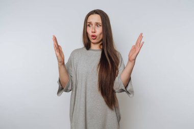 Endişeli genç bir kadının portresi, arka plandaki el hareketleriyle inançsızlığını gösterir.