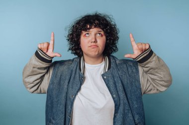 Genç bir kadının portresi ellerini gökyüzüne kaldırır, mavi arkaplanda derin derin düşüncelere daldığını gösterir.