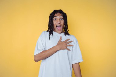 Açık ağızlı ve geniş gözlü genç bir adamın portresi sarı arka planda heyecan ve şaşkınlık ifade eder.