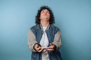 Genç bir kadının portresi mavi arka plana bakarken hareketli bir oyun oynuyor