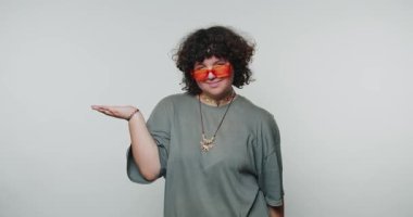 Neşeli genç kadın elini ifade ederek beyaz arka planda neşe ve bağ kurmaya çalışıyor.