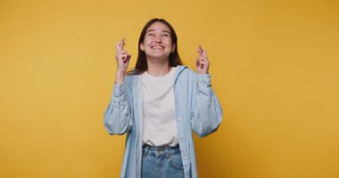 Genç bir kadın umut verici bir ifadeyle umut dolu sarı arka planda umut ve beklentiyi sembolize ediyor..